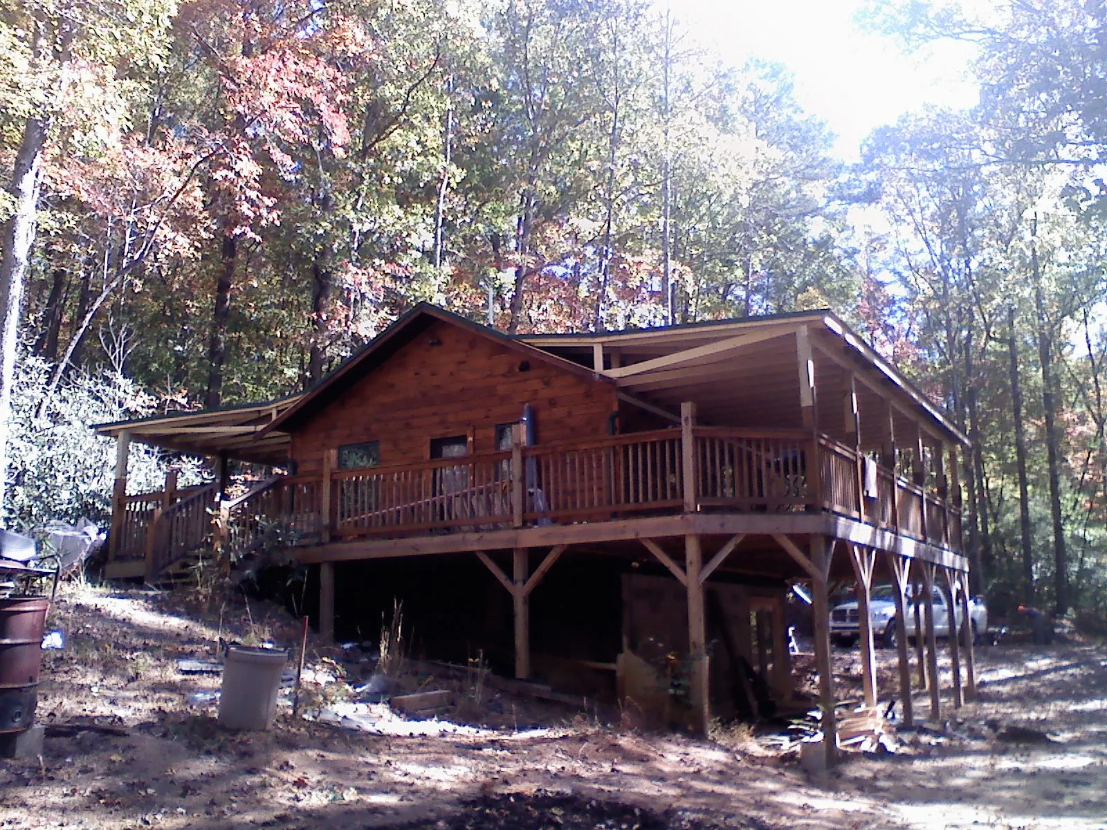 Log cabin with a wraparound porch and metal roof in the fall in Jamul